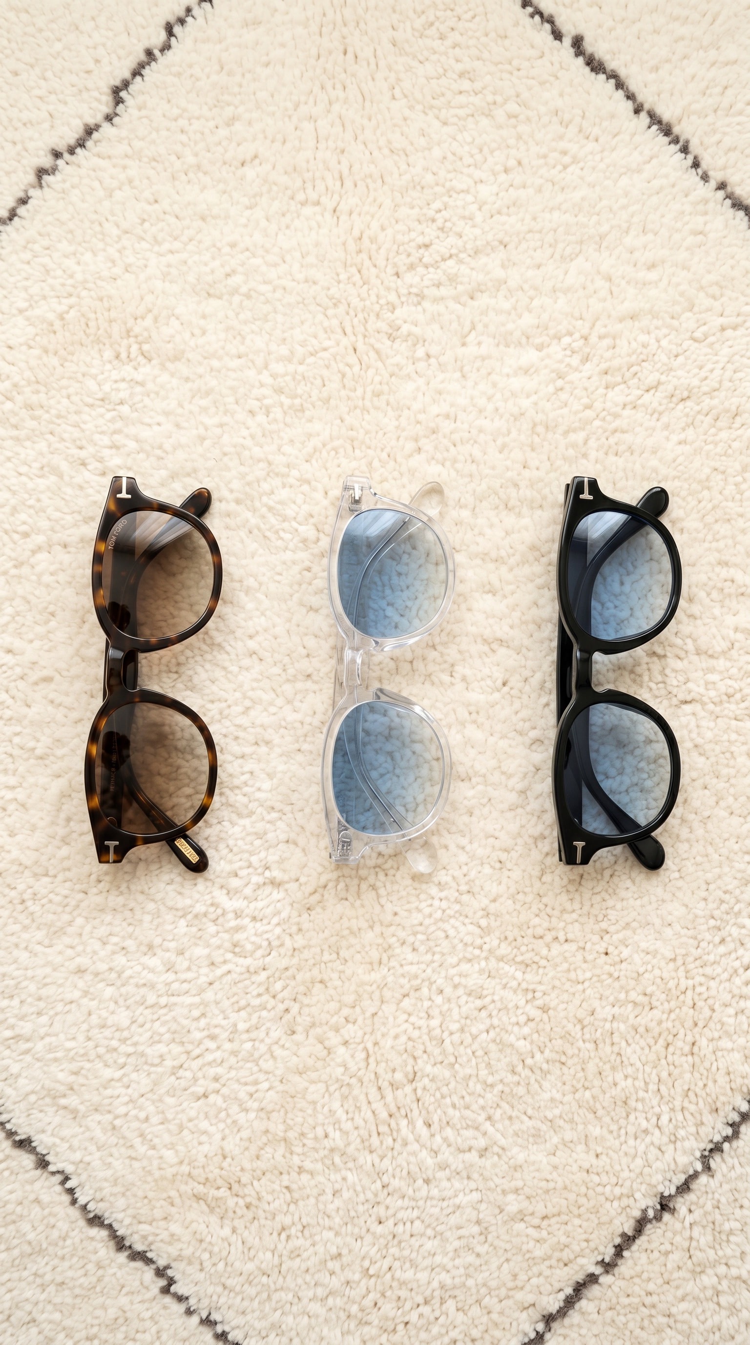 Product flat-lay of three pairs of round sunglasses on a rug