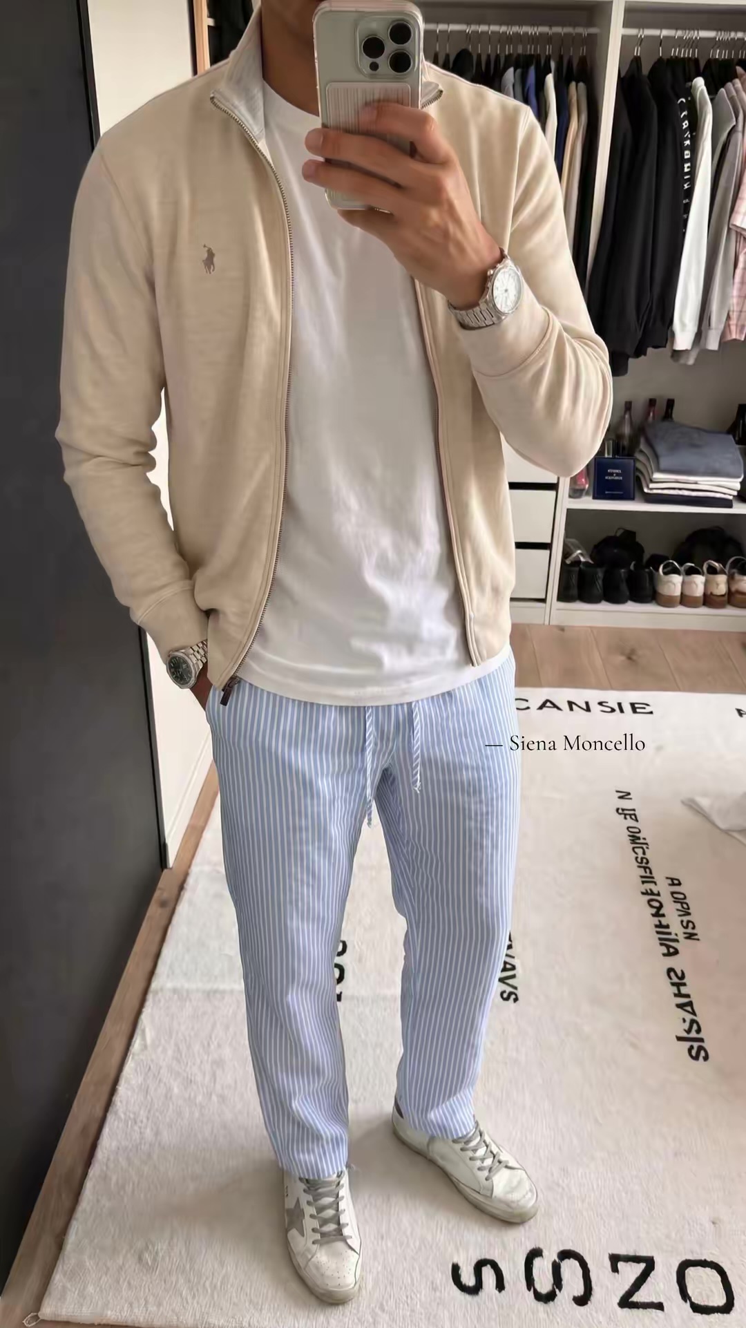On-model mirror photo of a Siena Moncello cream track jacket, white tee and striped trousers